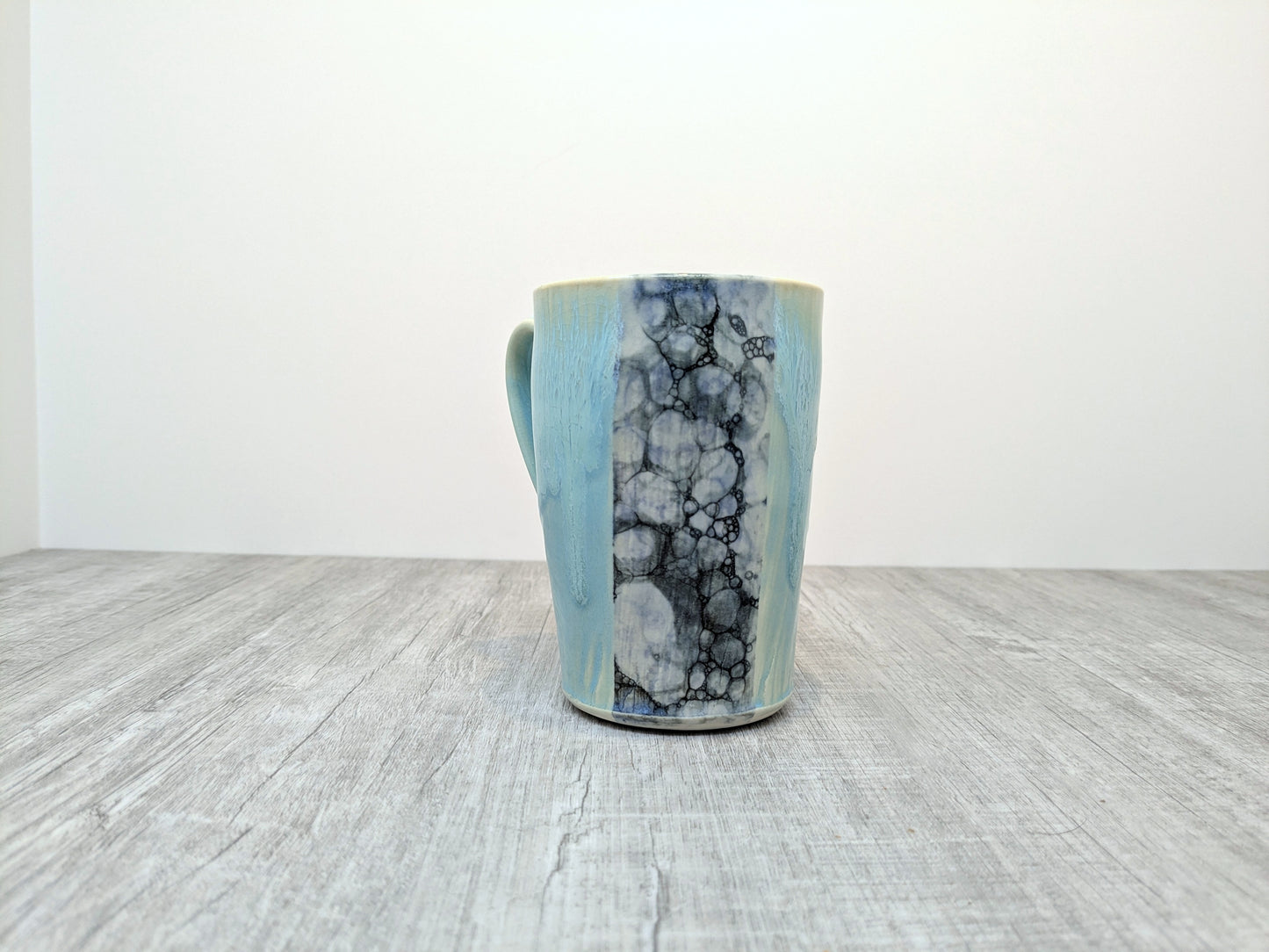 Blue Drip Glaze Pottery Mug with Abstract Pebble Design